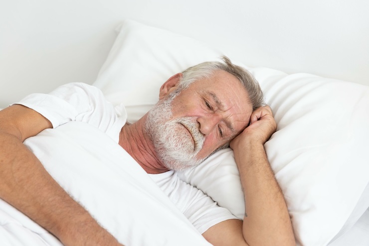 Worried senior retirement man lying awake in his bed