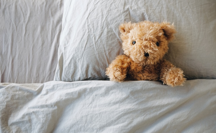 Lonely Teddy Bear lying on the bed