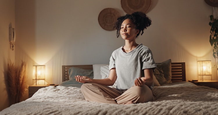 person meditating in bed