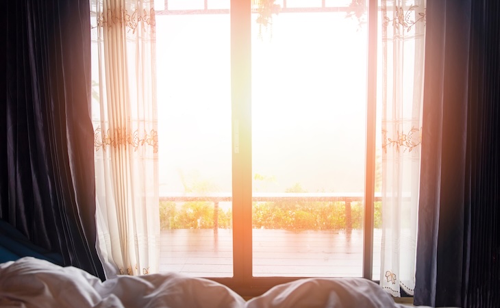 window view nature green mountain in the bed at bedroom morning and sunlight / window glass with drapery