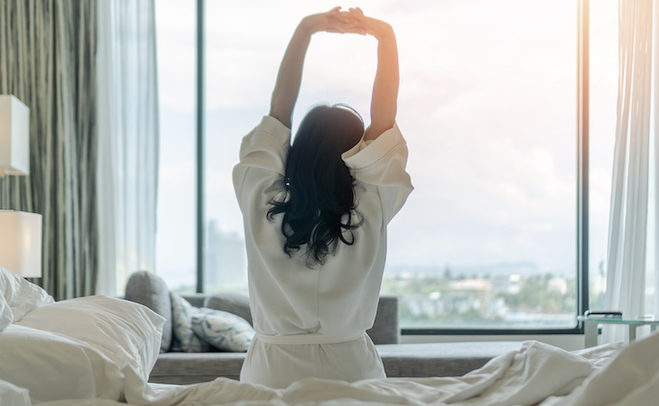 person waking up after good night sleep in hotel