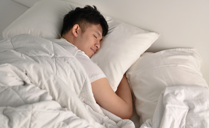 person sleeping late on weekend in bed