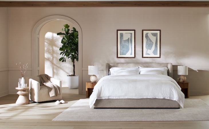 nature-inspired bedroom with large plant, and bed with linen duvet