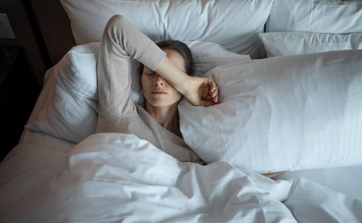 young woman appearing tired and in distress after waking up