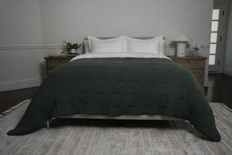 Dressed bed with green quilt