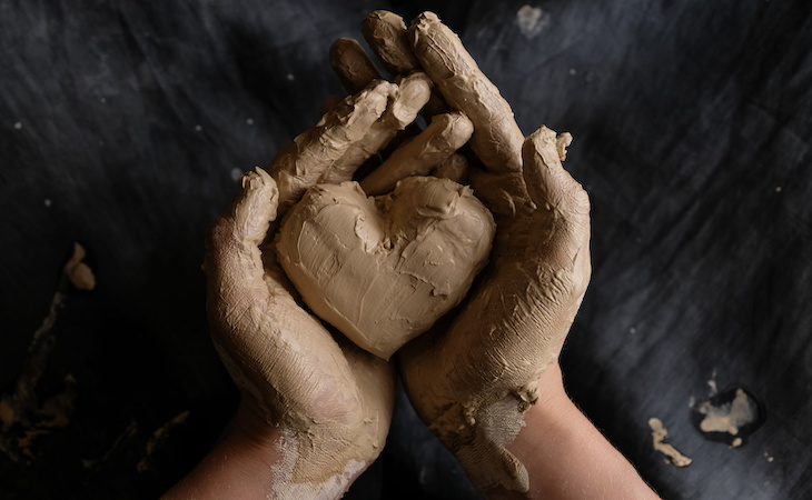 Person crafting a heart out of clay