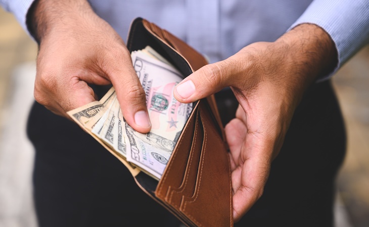 person taking money out of wallet - mattress tariffs